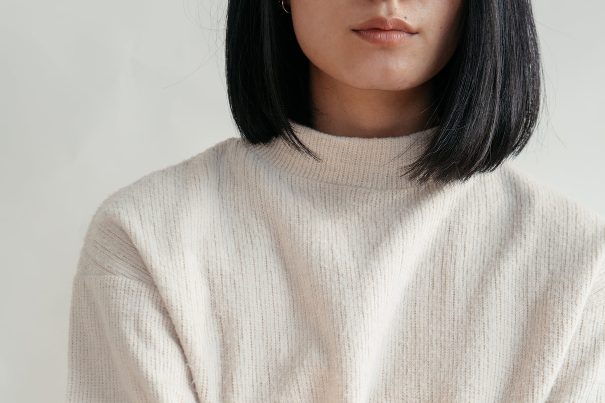 Detail of a cream knit cotton sweater
