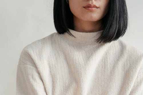 Detail of a cream knit cotton sweater