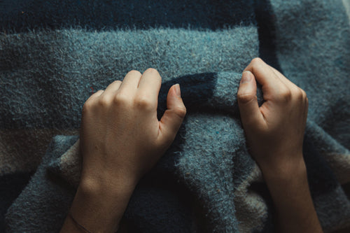 Hands holding a thick cozy weighted blanket